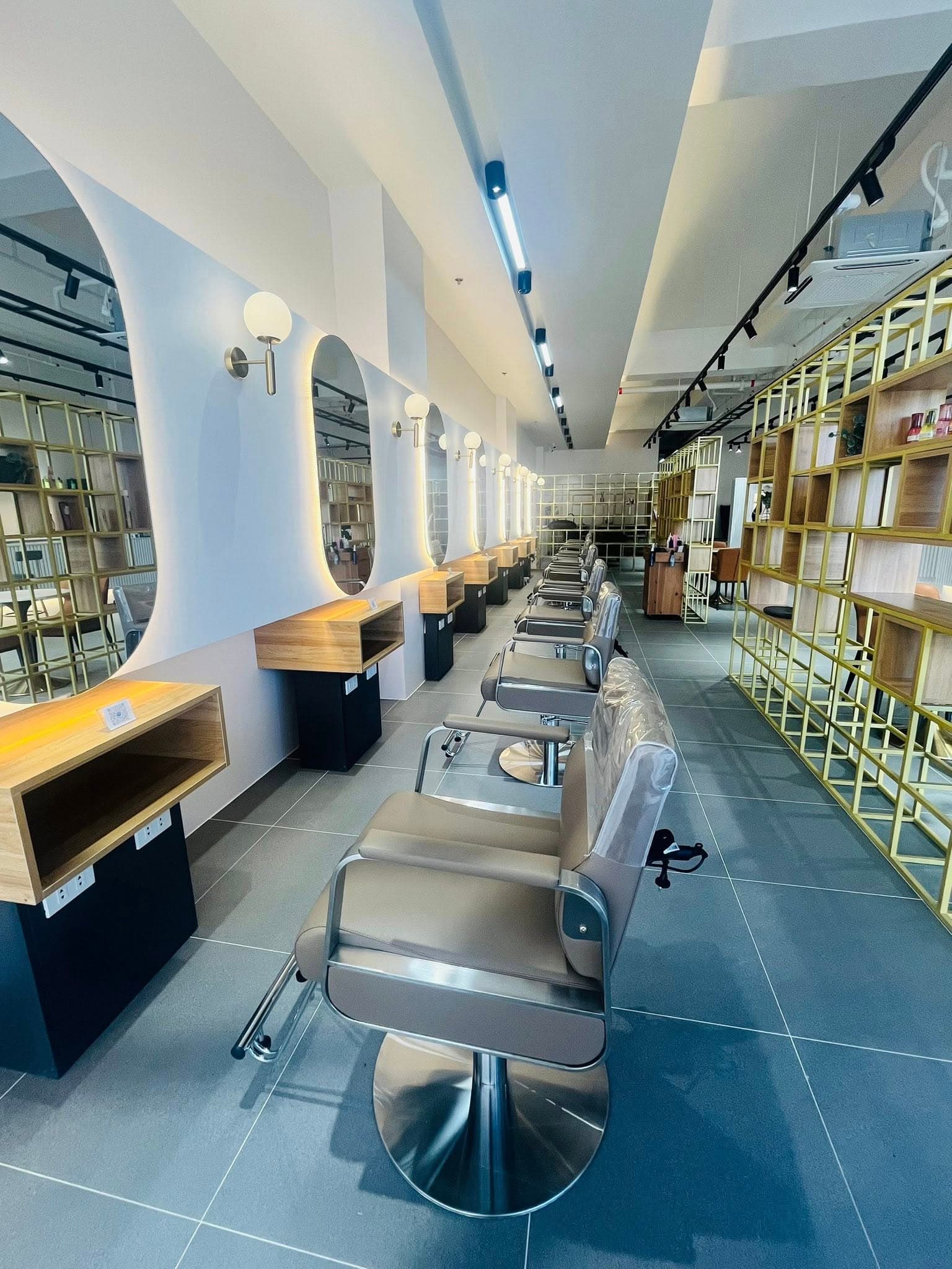 Hana Hair salon interior — styling stations with gold shelving